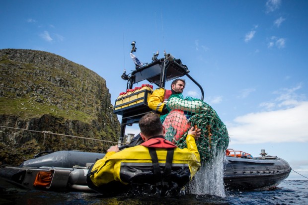 Crew from the Beluga II load plastic cleaned from beaches on Eilean Taighe into a rhib to be taken and disposed of.