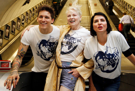 Three people at the bottom of an escalator wearing matching Save the Arctic t-shirts