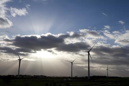 Wind turbines with sunshine and clouds in the background