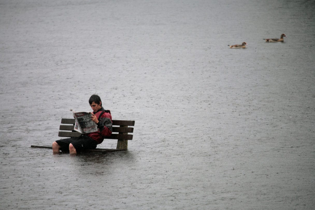 person sitting on bench in flooded area