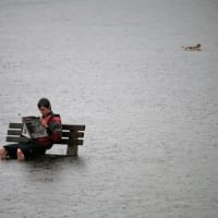 person sitting on bench in flooded area