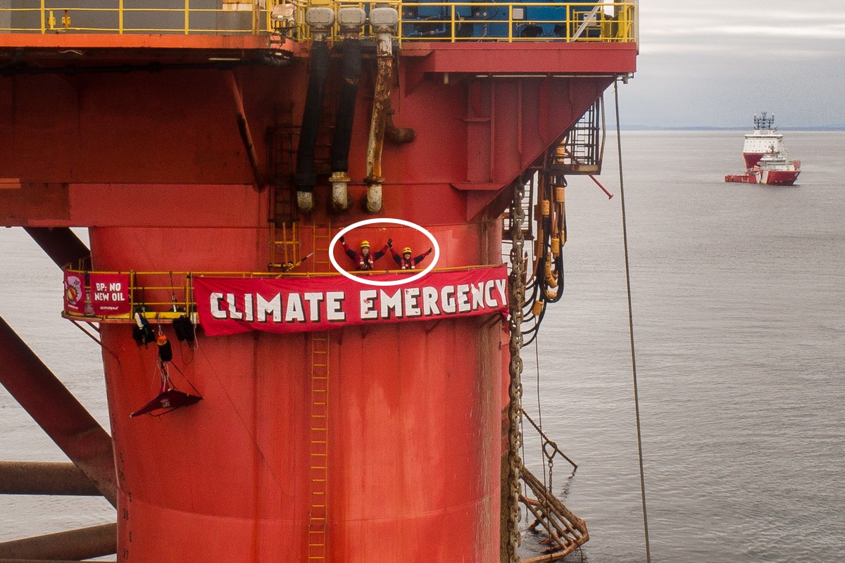 activists on oil rig with banner