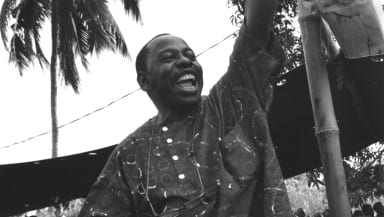 Ken Saro-Wiwa holds their fist in the air triumphantly