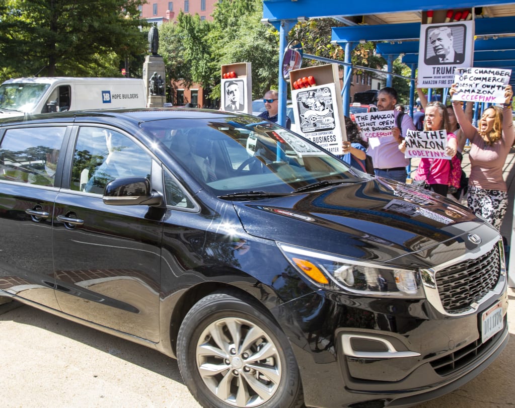 Car with Salles inside arriving at the US Chamber of Commerce in Washington DC, where he is greeted by protestors from Greenpeace, Code Pink Amazon Watch, Brazilians for Democracy and Social Justice and Code Pink.