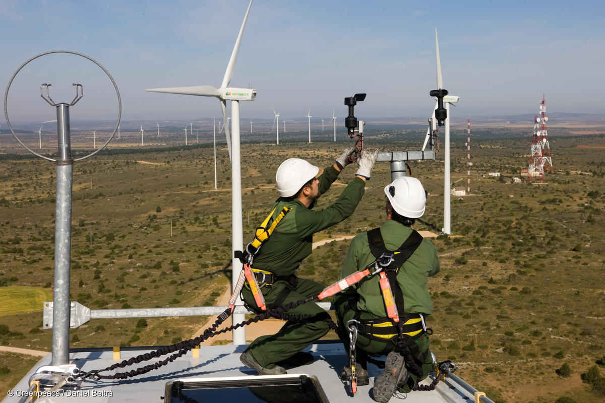 Technicians inspect equipment on the top of a wind turbine. A just transition would help workers find good jobs in emerging clean industries.