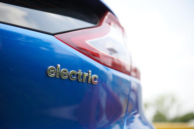 Closeup of the back of a modern car with the word 'electric' embossed on the paintwork.