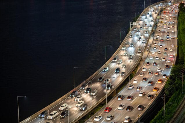 Heavy traffic on a multi-lane elevated motorway at night.