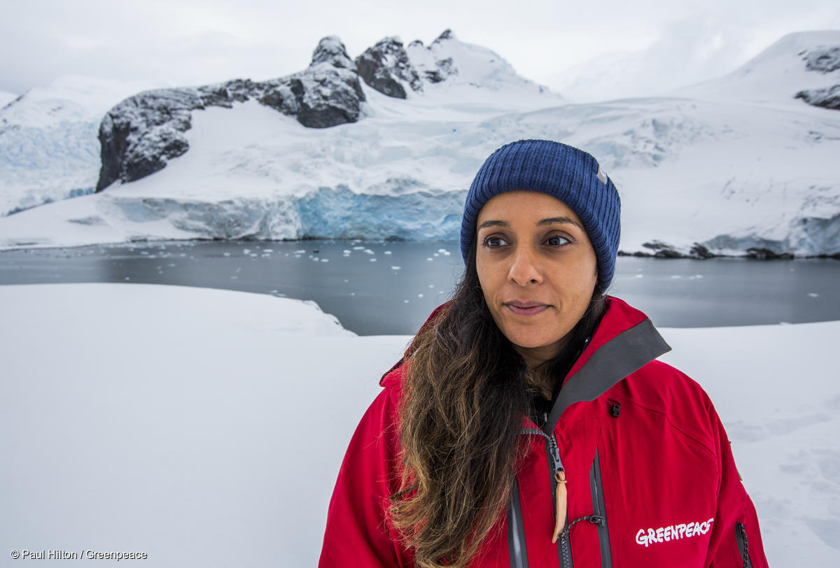A young woman in a red jacket standing in an icy polar landscape