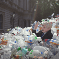 Still from animated film showing Boris Johnson being swept away by a wave of plastic waste