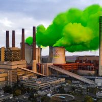 Photo illustration shows plumes of green steam coming from a power station cooling tower