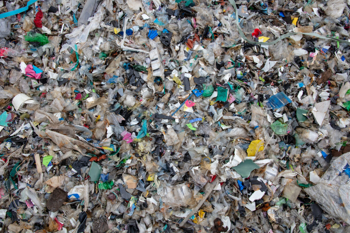 Overhead view of a jumble of dirty shredded plastic waste.