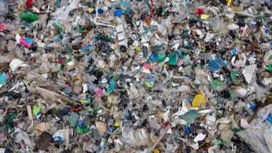 Overhead view of a jumble of dirty shredded plastic waste.