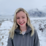 Headshot of Miranda Barrie in a snowy landscape, smiling broadly into the camera