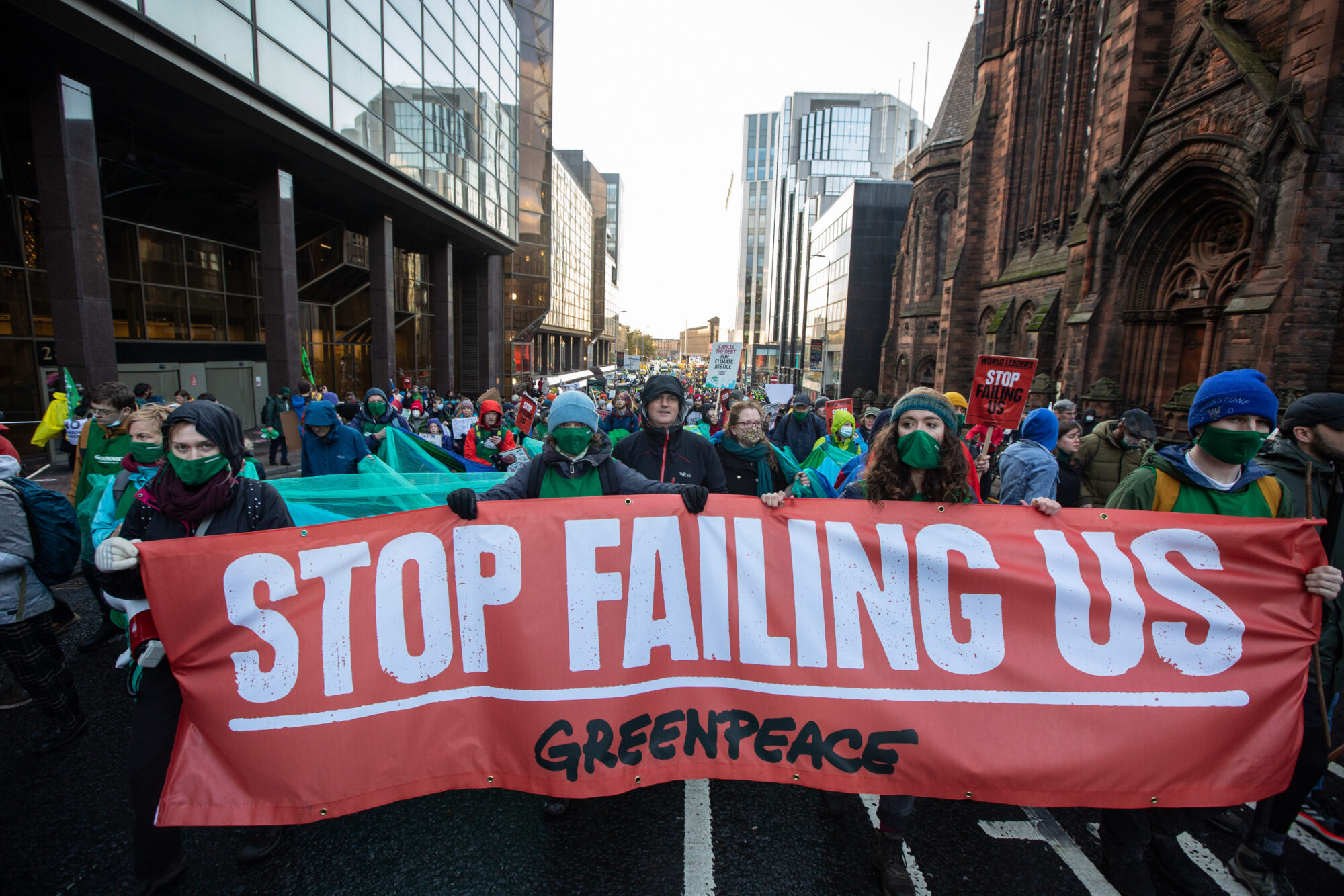 Large group of people holding a sign that says "Stop failing us". They march along the streets of Glasgow city for the Global Day of Action for COP26.