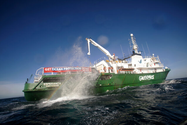 A boulder throws up a plume of rainbow spray as it's released from the Greenpeace ship Esperanza into the sea.