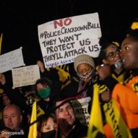 Protesters at night for Kill the Bill protest with banner that reads "No #Policecriminalisationbill They Wont Protect Us, They'll Attack Us"
