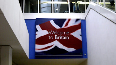 A large sign saying 'Welcome to Britain' against a Union flag