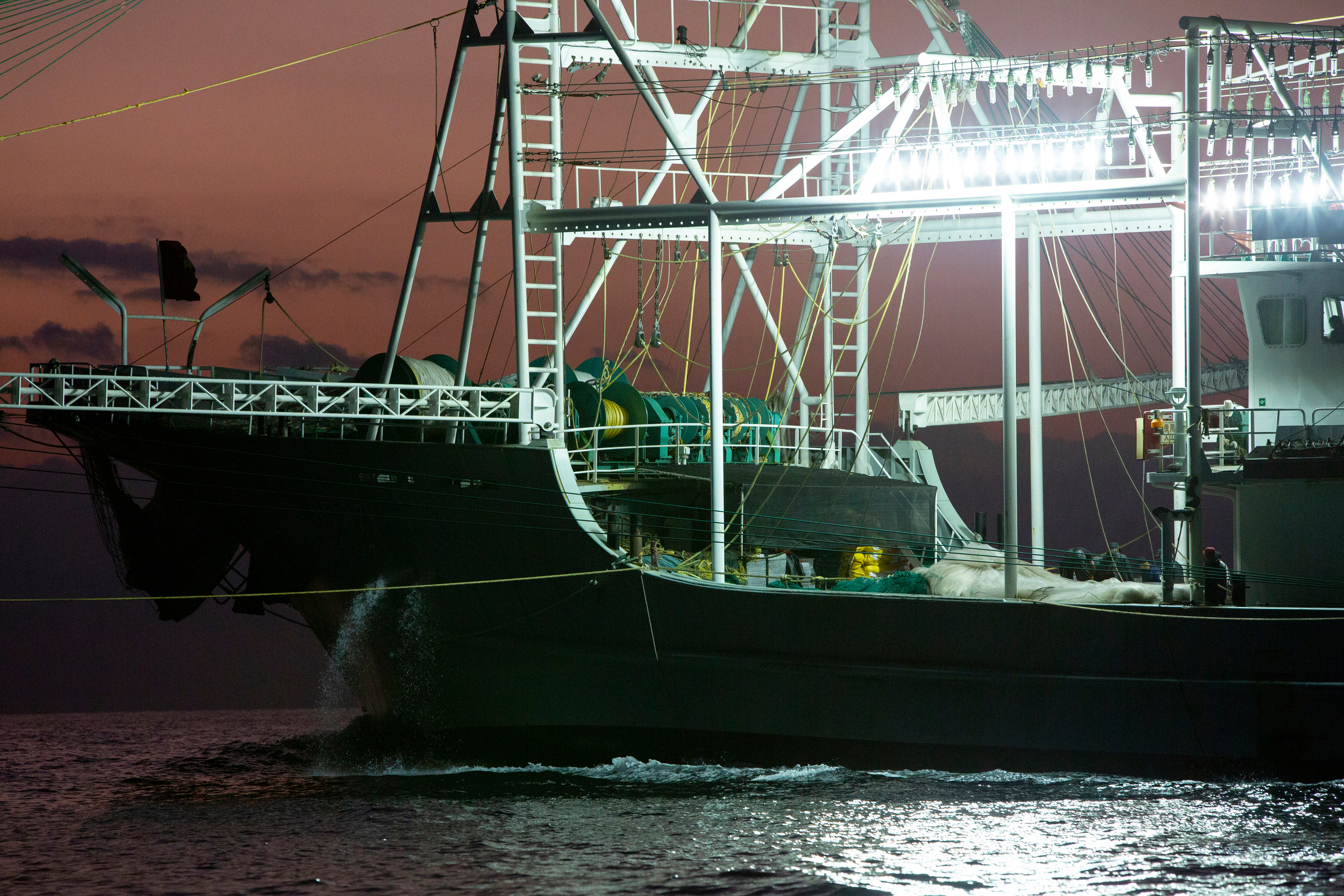 Squid fishing boat shines its lights brightly onto the sea