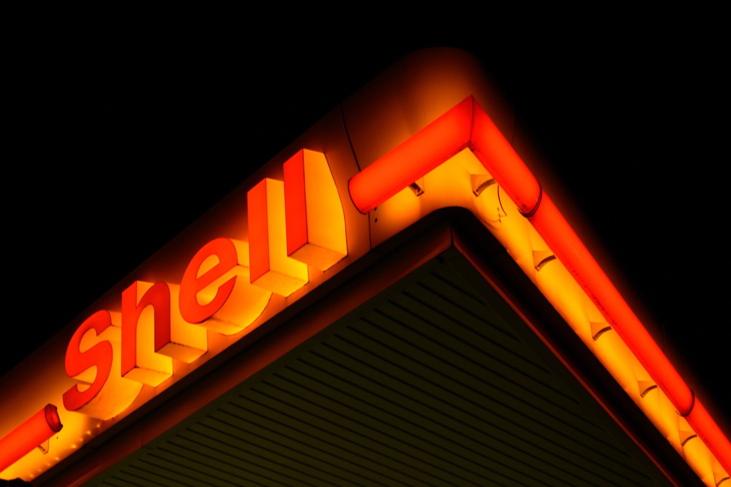 An illuminated red and yellow Shell sign at night