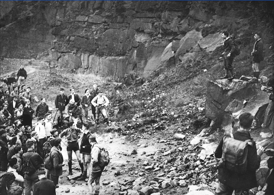 Kinder mass trespassers in Bowden Quarry in 1932. Leaders of the group stand on quarry rocks talking to the large crowd below them.
