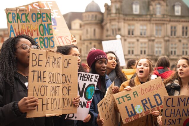 Group of women holding signs at a climate protest. The ones we can easily read say: ‘Be part of the solution, not part of the pollution’ and ‘It’s a beautiful world, let’s keep it that way!’