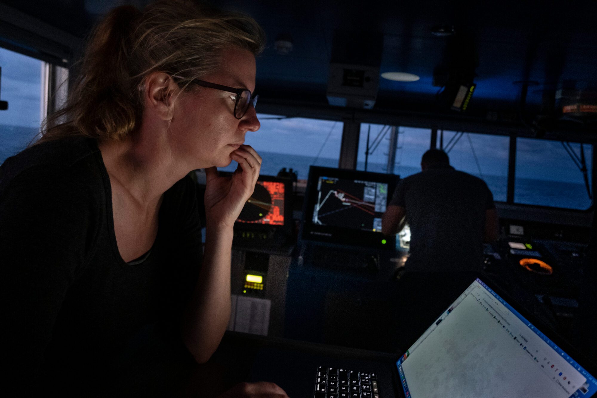 Standing on the darkened bridge of a ship, Sophie Cooke's face is illuminated by the radar screen she's examining.