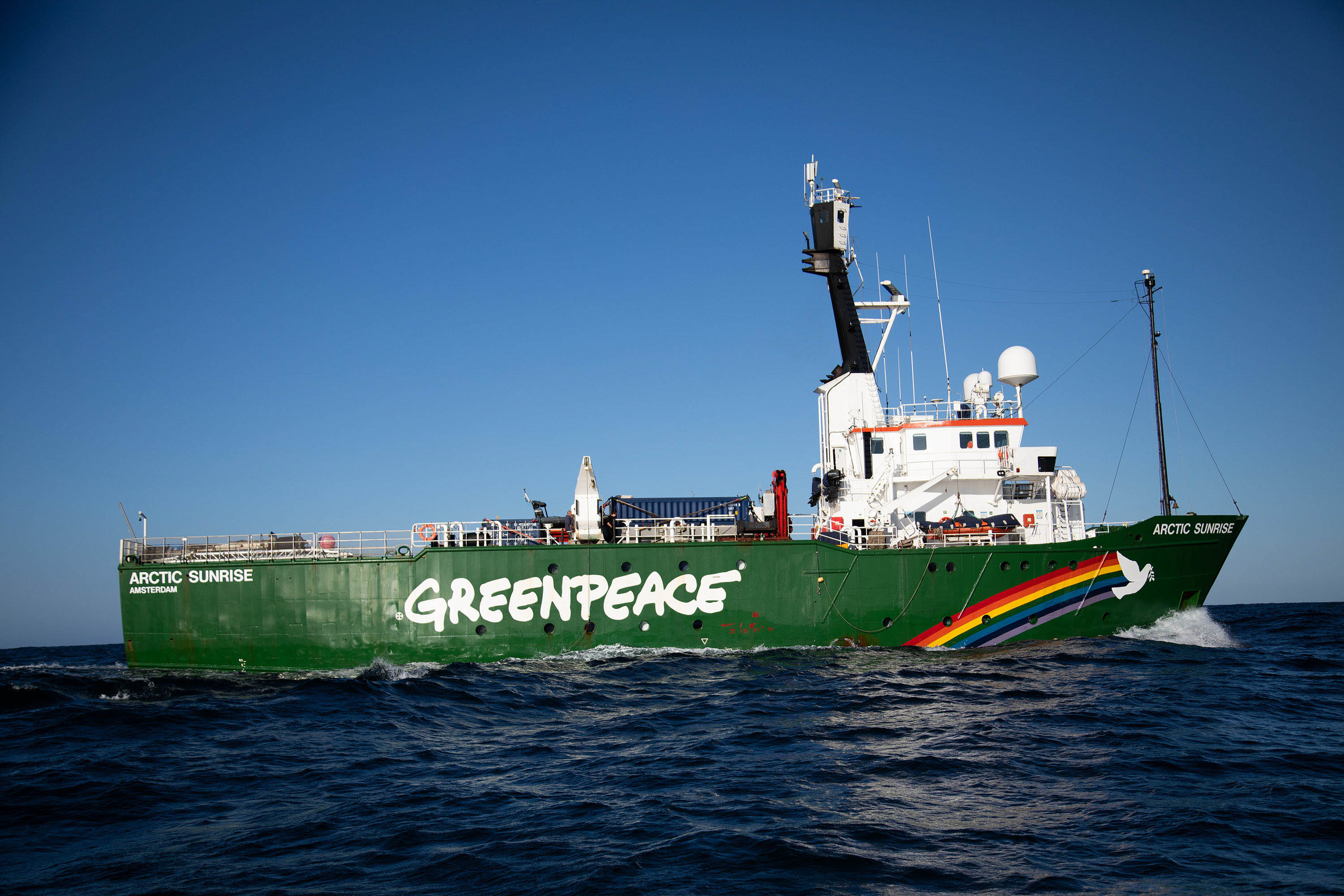 Greenpeace ship MY Arctic Sunrise on the sea with a clear blue sky above.