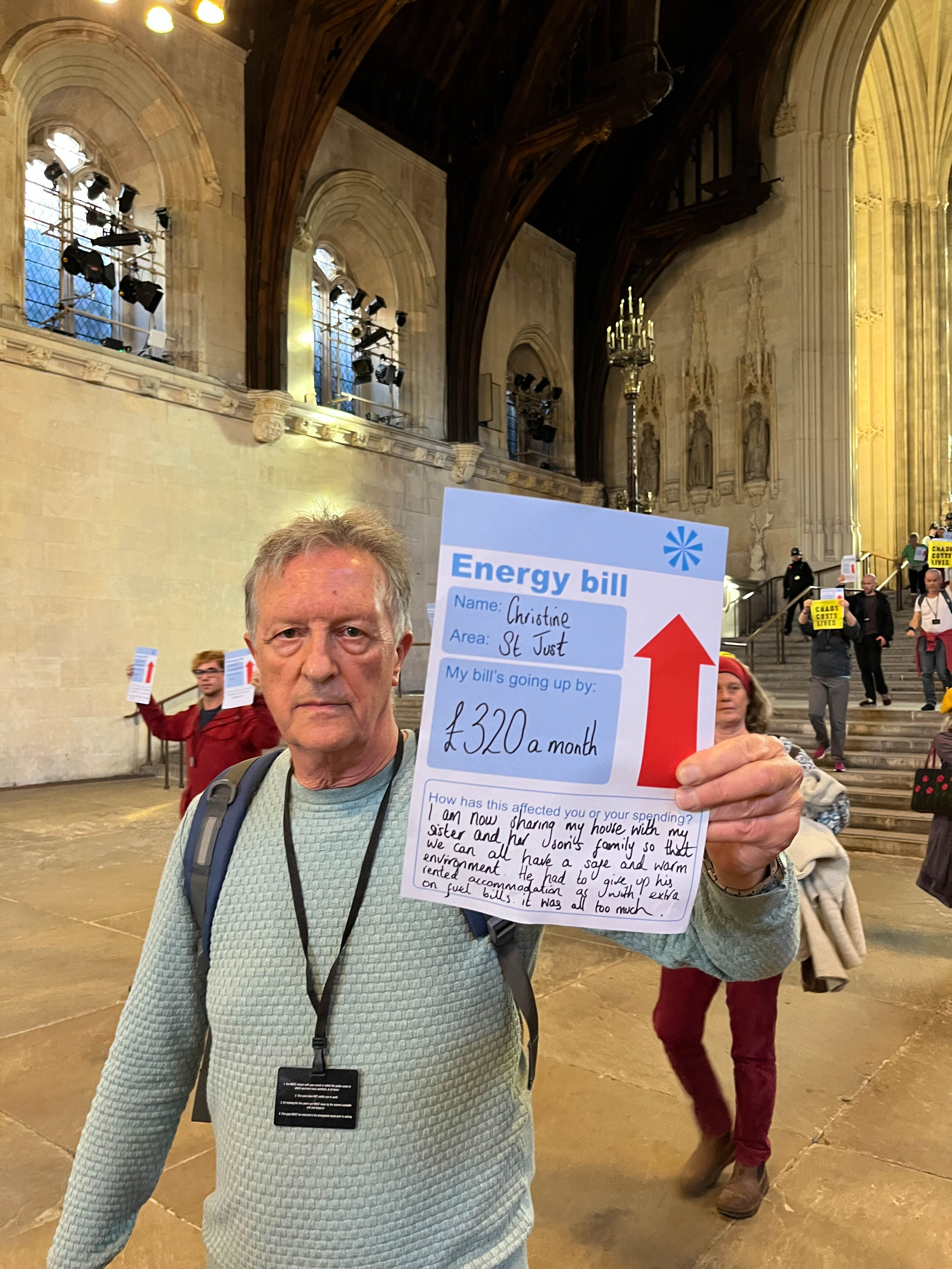 Activist holds an energy bill from Christine in St Just saying that their bill is going up by £320 a month.