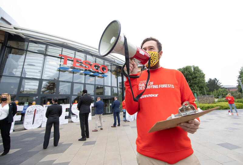 An activist speaks into a megaphone outside a Tesco store