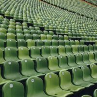 A bank of green stadium seating, all empty, used to illustrate the concept of sportswashing.