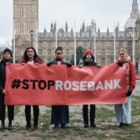 5 people stand in front of the House of Commons holding a big red banner reading #StopRosebank