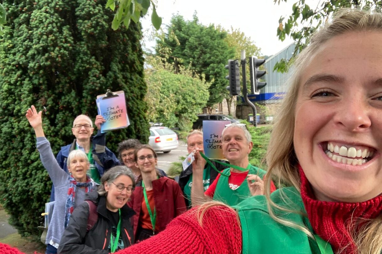 Smiling volunteers take a selfie with Project Climate Vote clipboards