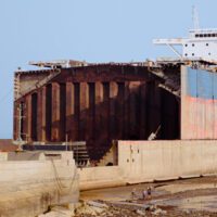 A half-dismantled ship sits folornly on dry land