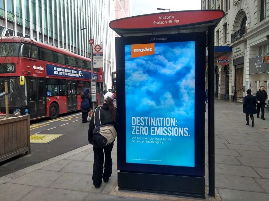 EasyJet bus advert of blue sky with a plane shadow. Text reads "Destination: zero emmissions. We are championing a future of zero emission flights"