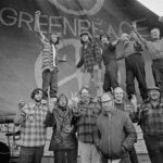 group of people stand in front of original greenpeace logo