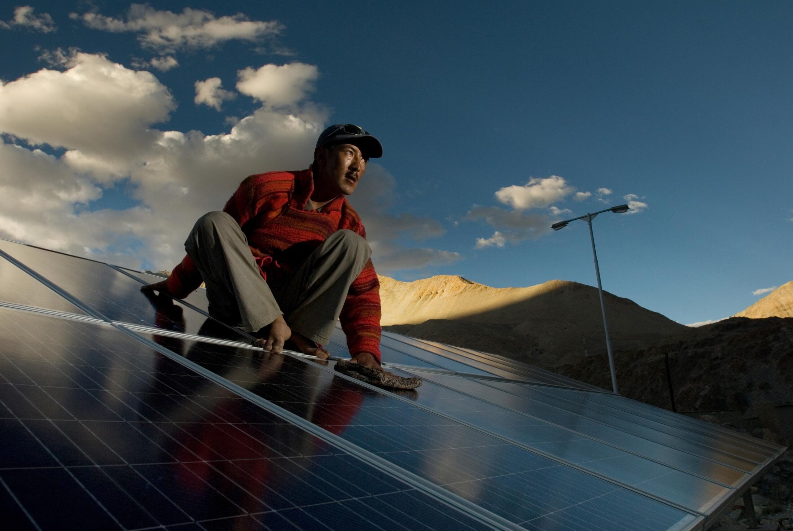 Person sitting on a roof with solar panels