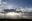 Wind turbines with sunshine and clouds in the background