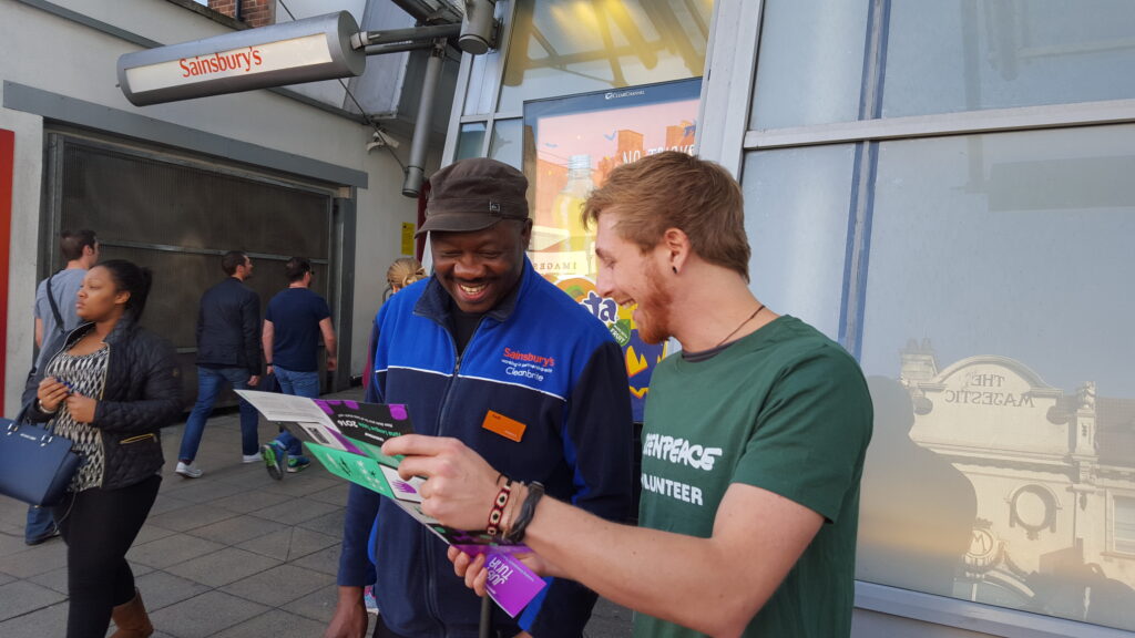 Greenpeace volunteer speaking to a member of the public