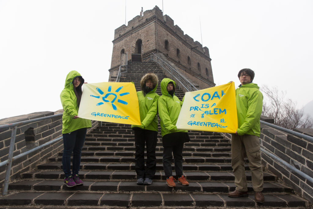 Greenpeace demonstrators on the Great Wall of China hold banners saying coal is a problem