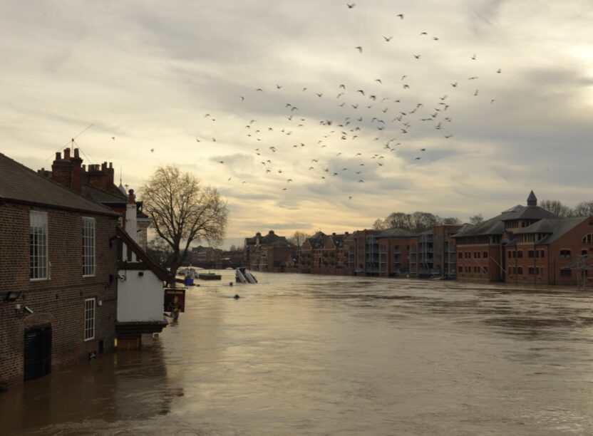 A flooded river running through an old city in watery winter light
