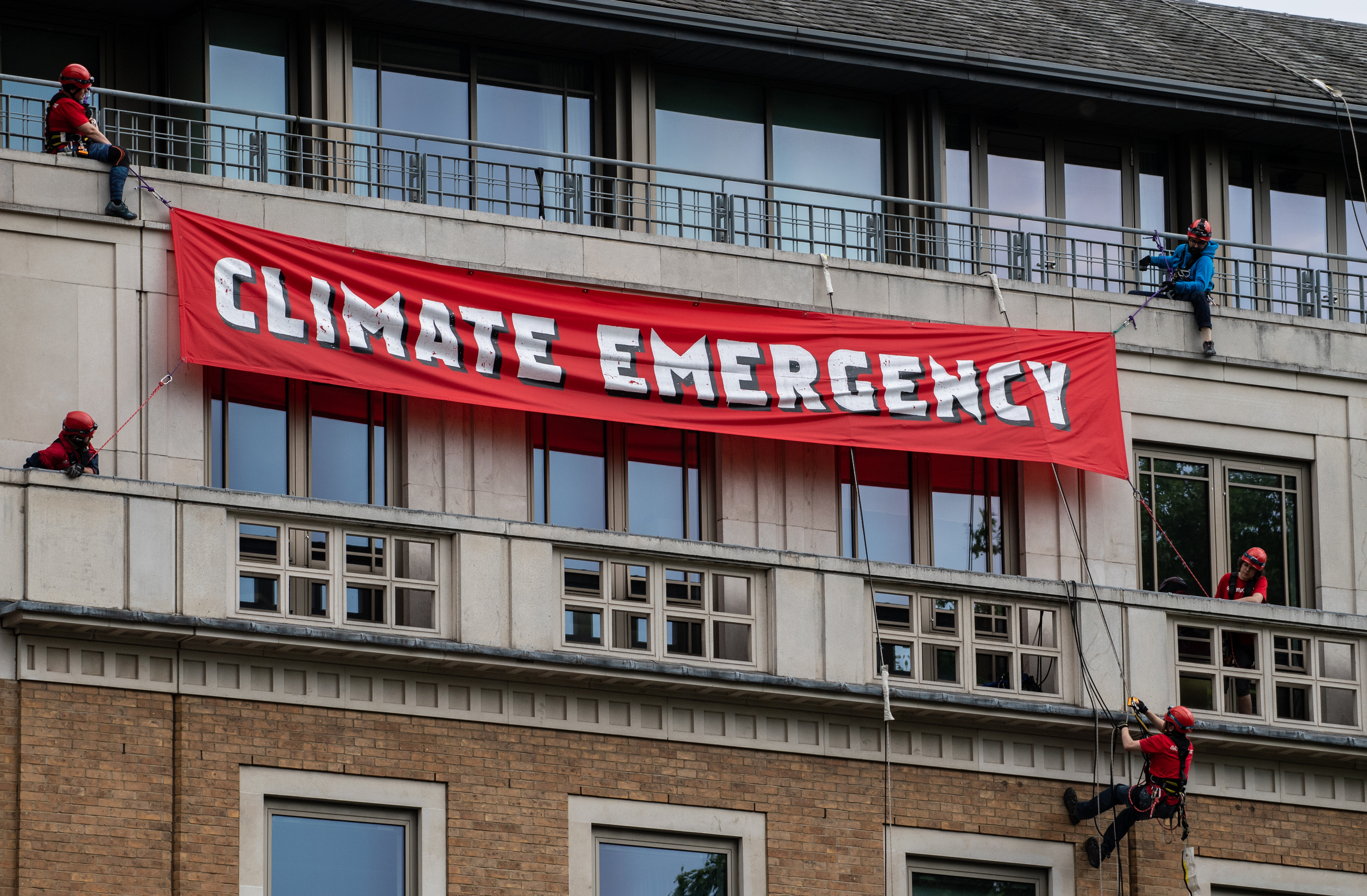 climbers with banner on top of building