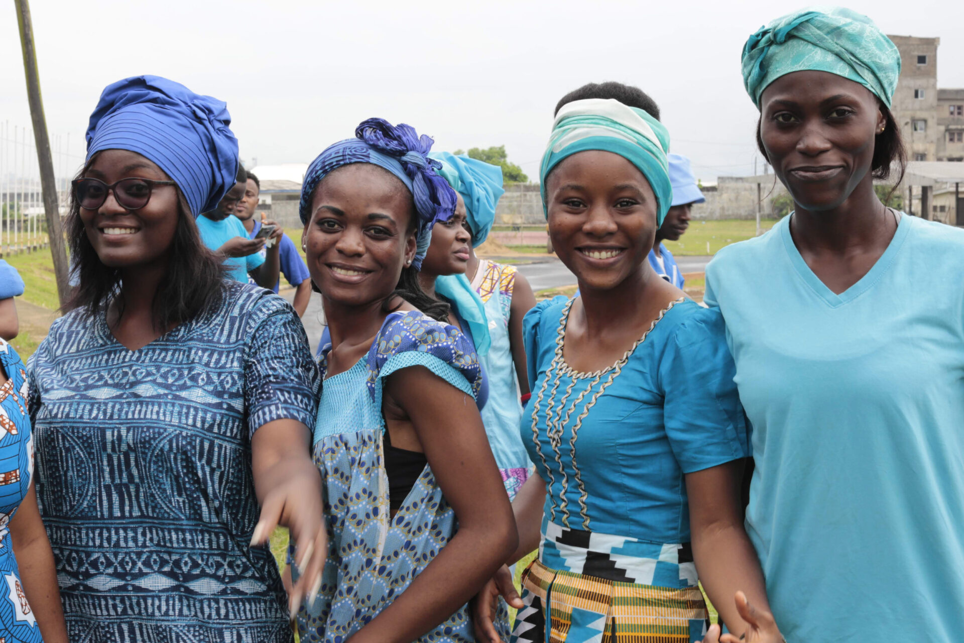 A group of volunteers dressed in bright blue clothes smile into the camera.
