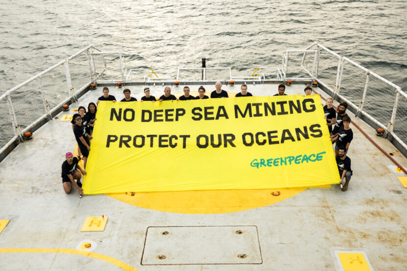 ship crew hold a banner on deck