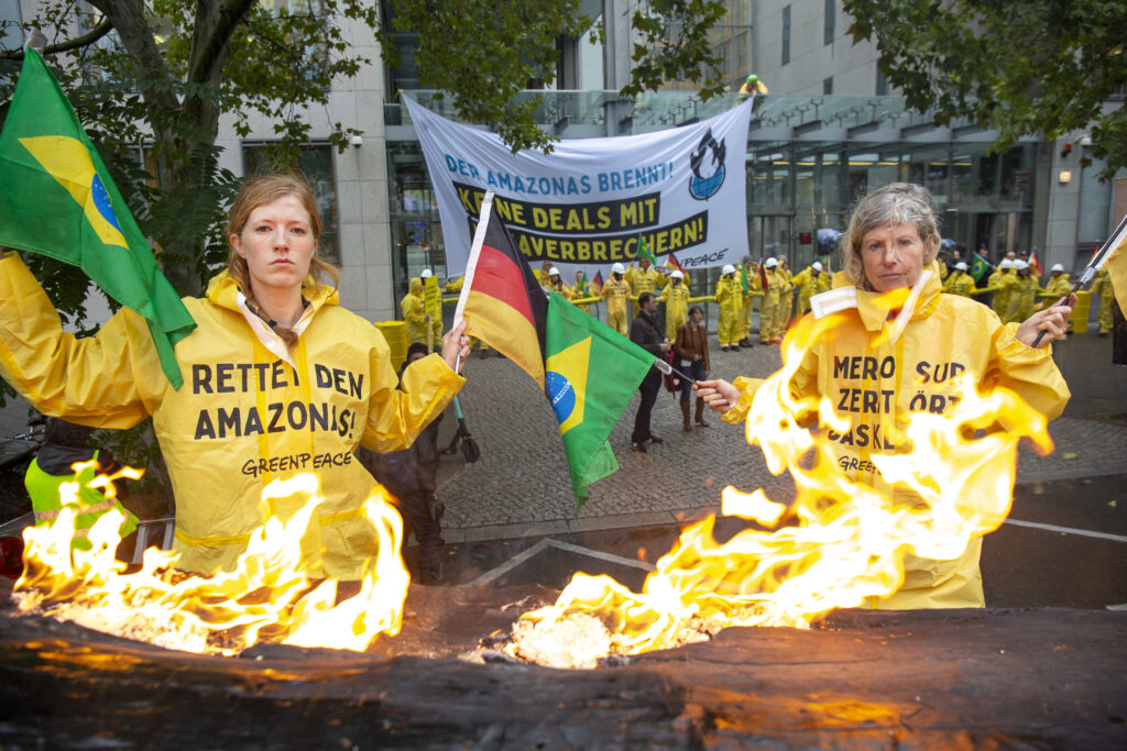 German Greenpeace protesters with burning tyres protesting Salles.
