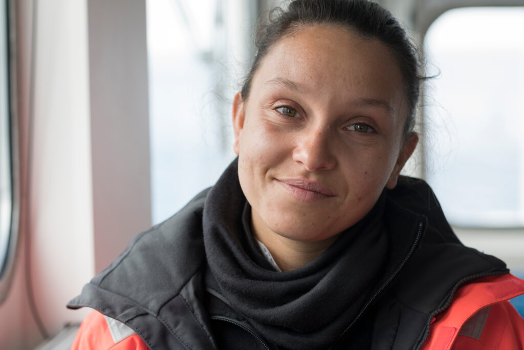 Simone wears a boat jacket and smiles into the camera