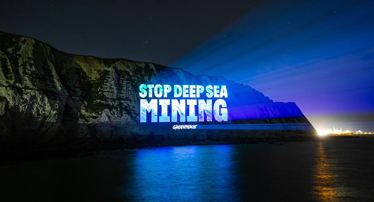 Stop deep sea mining projection on sea cliffs at night