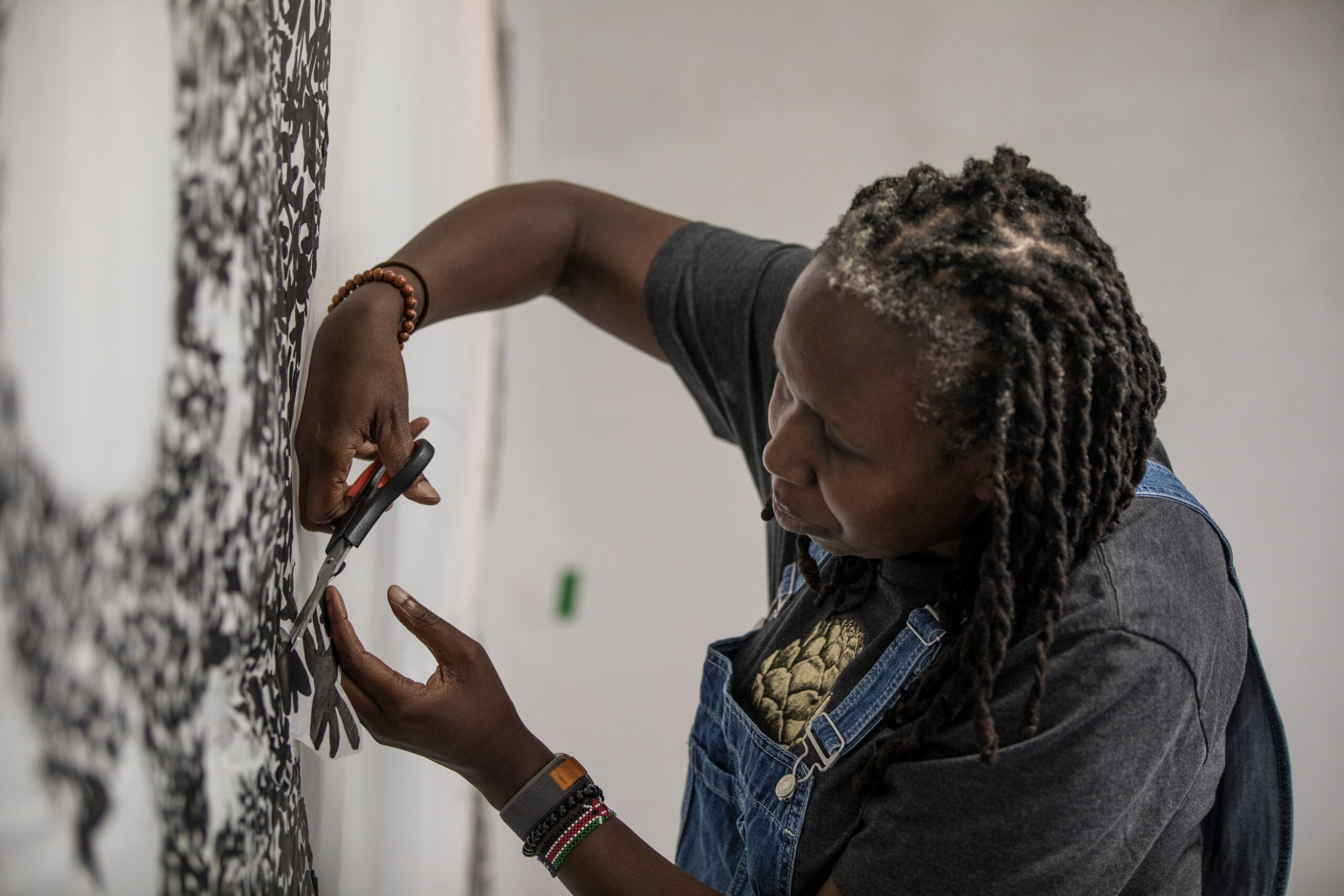 Artist JC Niala carefully cuts shapes into paper in the studio.