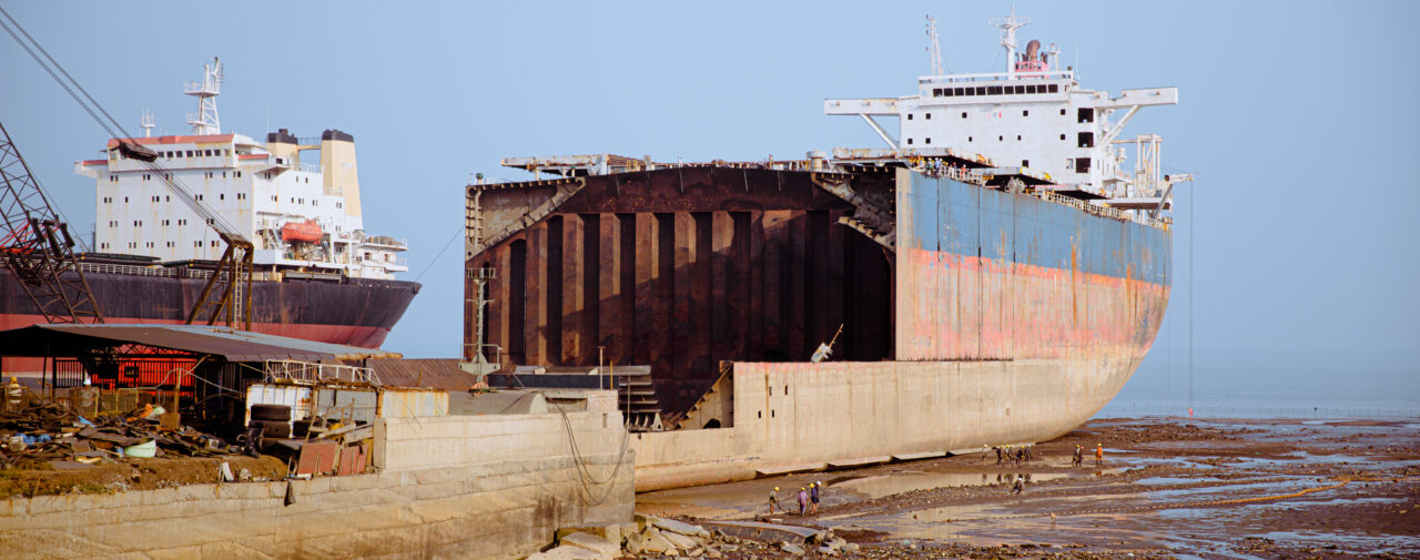 A half-dismantled ship sits folornly on dry land