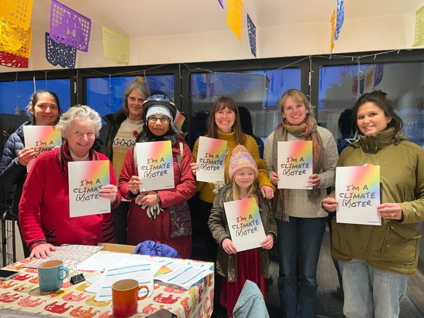 A group of volunteers holding up posters that say 'I'm a climate voter'