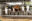 A group of cows poke their heads through metal bars on an industrial farm